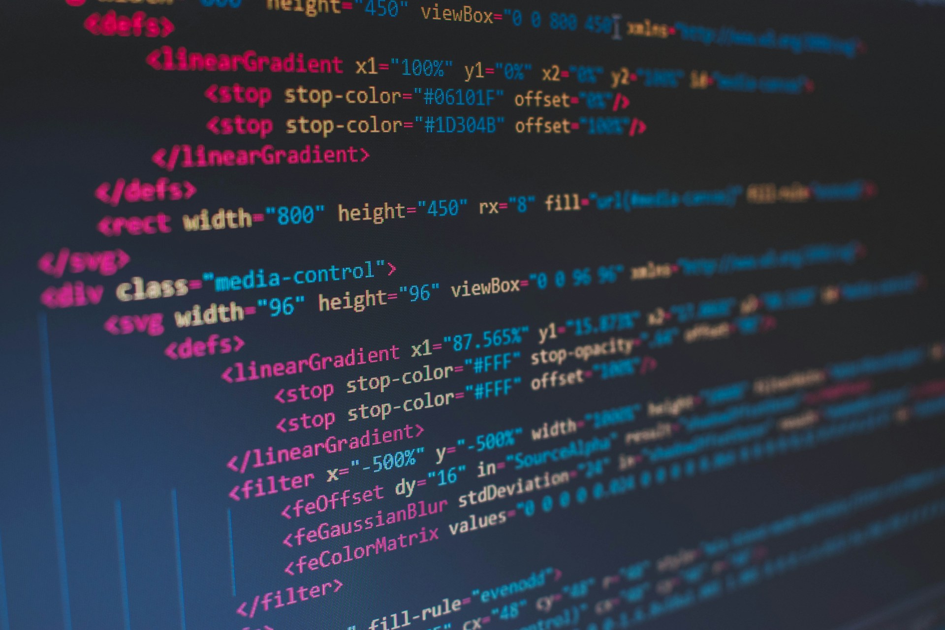 Gros plan d’un écran affichant du code source coloré sur fond sombre.